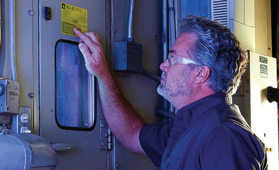 A project team member inspects a UV lamp installed in one of LAX’s more than 200 air handlers